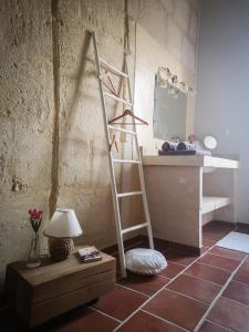 een kamer met een ladder, een spiegel en een tafel bij Mas de l'Hermitage in Moulès