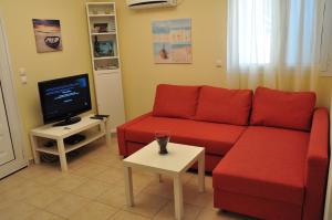 sala de estar con sofá rojo y TV en Casa Bella a Skala 2, en Skala