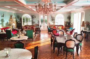 a dining room with tables and chairs and a chandelier at The Glenburn Penthouse in Kolkata