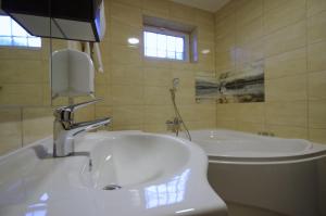 a bathroom with a sink and a tub at Central Panzió Gyula in Gyula +219 photos