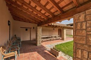 an outdoor patio with chairs and a wooden pergola at Torre d'en Bru in Vic