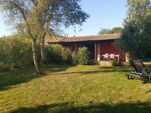 una casa rossa con una panchina in un cortile di Tenuta Santa Maria a Campagnatico