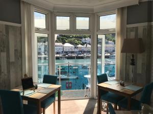 a room with a large window and a table with a laptop at Shellseekers Guest House in Looe
