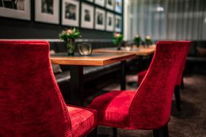 mesa con 2 sillas rojas y mesa de madera sidx sidx sidx sidx en Romantik Hotel Kleber Post en Bad Saulgau