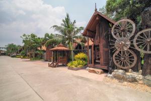 a building with two largeoked wheels next to a street at Suankaew Art Cottage in Ban Tha Sai