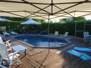 a patio with an umbrella and a swimming pool at prehistogite in Saint-Geniès