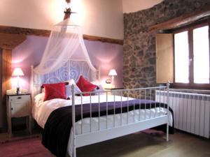 1 dormitorio con cama con dosel y almohadas rojas en Apartamento rural Casa Arritxenea, en Leitza