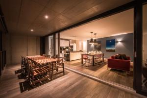 Independance Penthouse في إنترلاكن: غرفة معيشة مع طاولة وأريكة حمراء