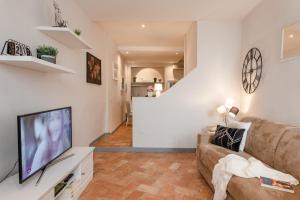 a living room with a couch and a flat screen tv at Ponte Vecchio - Flo Apartments in Florence