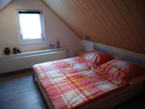 um quarto com uma cama e uma janela em Ferienhaus Rennsteig Müller em Lauscha