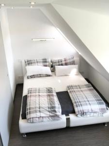 a bedroom with a white bed with plaid pillows at Modern Apartment Wolfsburg City Center Netflix VW 24h in Wolfsburg