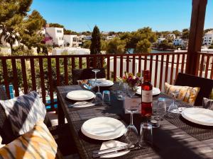 een tafel met borden en wijnglazen op een balkon bij Villa Imperial in Cala d´Or