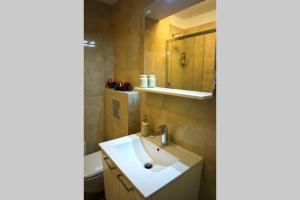 een badkamer met een witte wastafel en een spiegel bij Lacroma Apartment in Dubrovnik +20 foto's