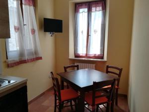 ein Esszimmer mit einem Tisch, Stühlen und Fenstern in der Unterkunft la corta di spello camere in Spello