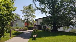 ein Gebäude mit einem Baum neben einem Bürgersteig in der Unterkunft Le Domaine (Swiss Lodge) in Freiburg im Üechtland