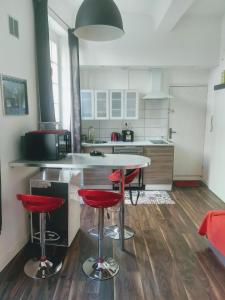 La Maison de Valentino في مارسيليا: مطبخ مع منضدة وكراسي حمراء فيه