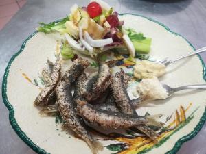 un plato de comida con salchicha y ensalada en Locanda dei Mercanti, en Crevacuore