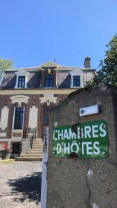 un cartel en una pared frente a un edificio en La maison au fil du temps en Pont-Rémy