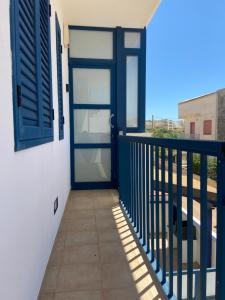 マリーナ・ディ・ラグーザにあるMareinSicilia: Appartamenti del Meloの景色を望むバルコニーに面した青いドア