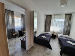 a hotel room with two beds and a mirror at Villa Marbela in Ustka