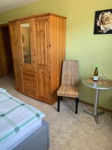 a bedroom with a table and a chair and a cabinet at Weingut J. A. Meyer in Wintrich