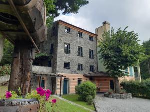 - une vue extérieure sur un grand bâtiment en pierre dans l'établissement Il Bosco di Campo Marzano Garden Apartments, à Borzonasca