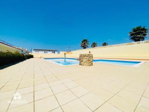 a patio with a pool in the middle of a building at Garden Park III in Ericeira