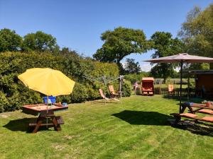 einen Picknicktisch mit gelbem Regenschirm auf dem Gras in der Unterkunft Haus Küstenheide in Cuxhaven