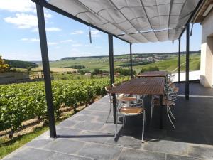 patio con mesa, sillas y vistas en gîte coeur de champagne en Romery