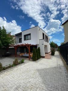 a white house with a patio and a fence at Vila Ammos Mamaia 120 Metri De Plaja in Mamaia Nord