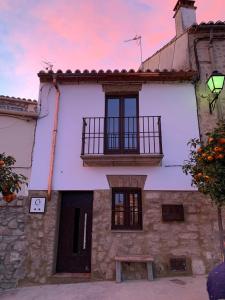 um edifício com uma varanda e um banco em frente em Casa Rural Turgalium em Trujillo