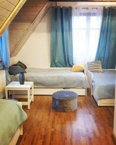 a room with two beds with blue curtains at Malowniczy Zakątek w Dercu in Derc