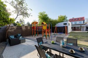 a backyard with a wooden table and a playground at Morska 5 in Niechorze