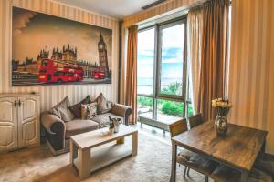 un soggiorno con un divano e un tavolo di IMPERA Boutique Apartments a Constanţa