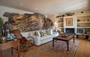 una sala de estar con un sofá blanco y una roca grande en Unique Villa on the Island of Poros en Poros