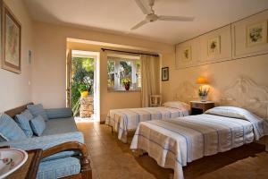 Habitación de hotel con 2 camas y sofá en Unique Villa on the Island of Poros en Poros