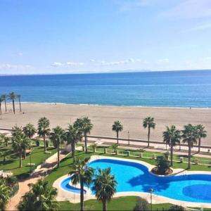 ロケタス・デ・マルにあるPrimera Linea De Playaのスイミングプールとビーチのあるリゾートの空からの景色を望めます。