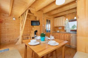 comedor con mesa de madera en una cabaña en Domki Rekin en Rewal
