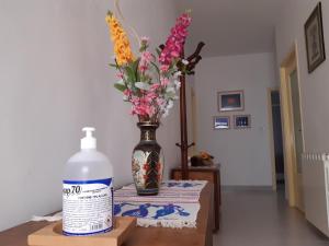 a bottle of water and a vase with flowers on a table at Appartamento per Turisti Mesovia in Santa Severina