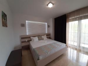 a bedroom with a bed and a large window at Apartament Sebastian - Vila Sophia 3 Mamaia in Mamaia
