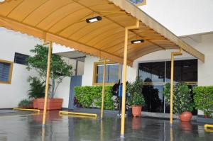 awning in front of a building with potted plants at Hotel Graunas in São Carlos