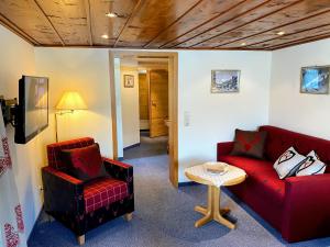ein Wohnzimmer mit zwei roten Sofas und einem Tisch in der Unterkunft Gatterhof in Riezlern