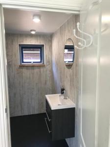 a bathroom with a sink and a window at Heerlijk huisje vlakbij de duinen van Oostvoorne in Oostvoorne