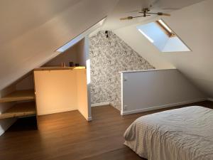 a attic room with a bed and a window at Duplex plein centre ville 3Etoiles in Le Mont-Dore