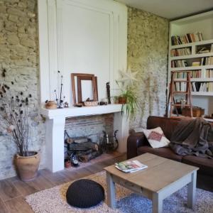 uma sala de estar com um sofá e uma lareira em Au Logis de la Mongie em Soullans