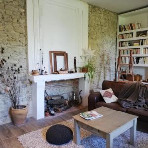 a living room with a couch and a fireplace at Au Logis de la Mongie in Soullans