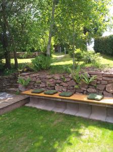 a wooden bench sitting in a stone wall at Ferienwohnung Tischneck in Schramberg