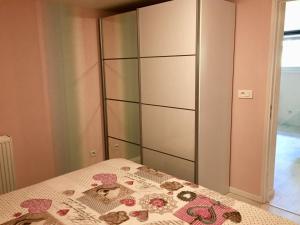 a bedroom with a bed and a large cabinet at Le Gîte de Brigitte ! in Saint Die
