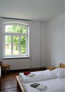 a white room with two beds and a window at Gutshaus Thorstorf FeWo Travemünde in Warnow