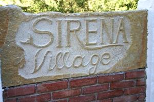 a sign on a brick wall with the words green village at Sirena Residence & Spa in Marathokampos